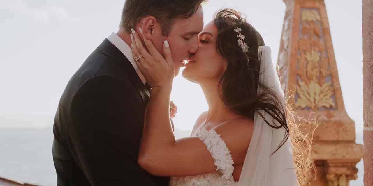 Cody and Lauren kiss at golden hour under the arches in Sarasota