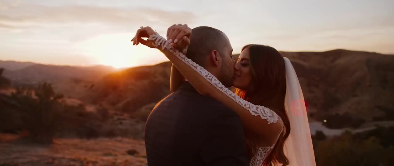 Edmond and Lauren kiss at golden hour above the hills at Hummingbird Nest Ranch