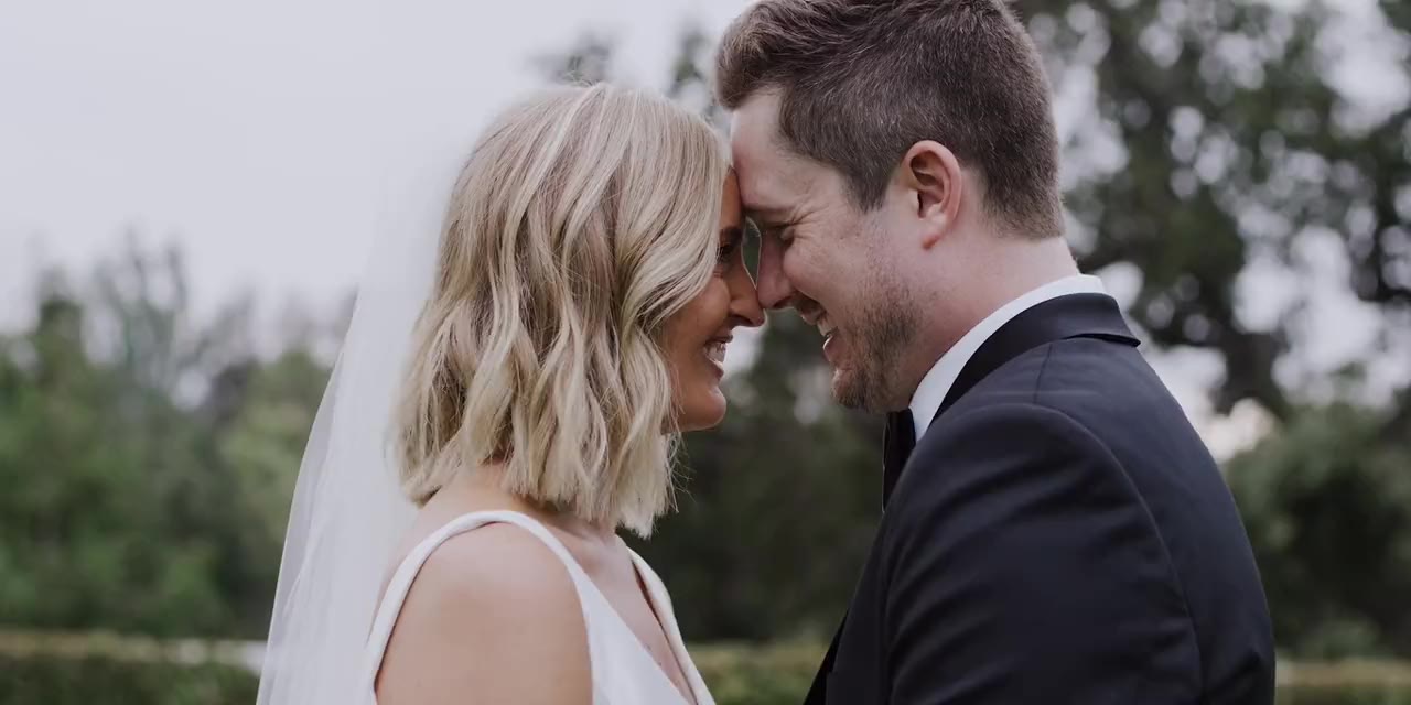 Max and Lauren forehead to forehead, a moment from their wedding film