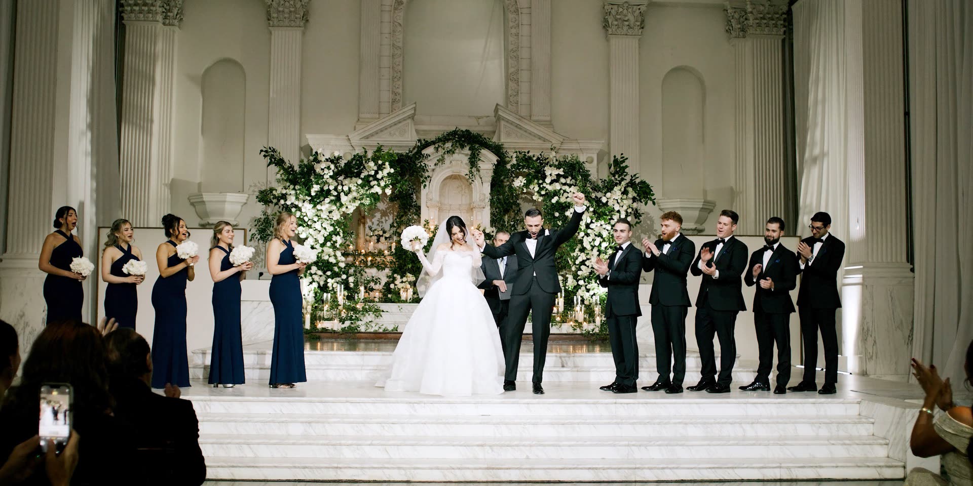 Bride and groom celebrating on the marble altar steps at Vibiana with their wedding party