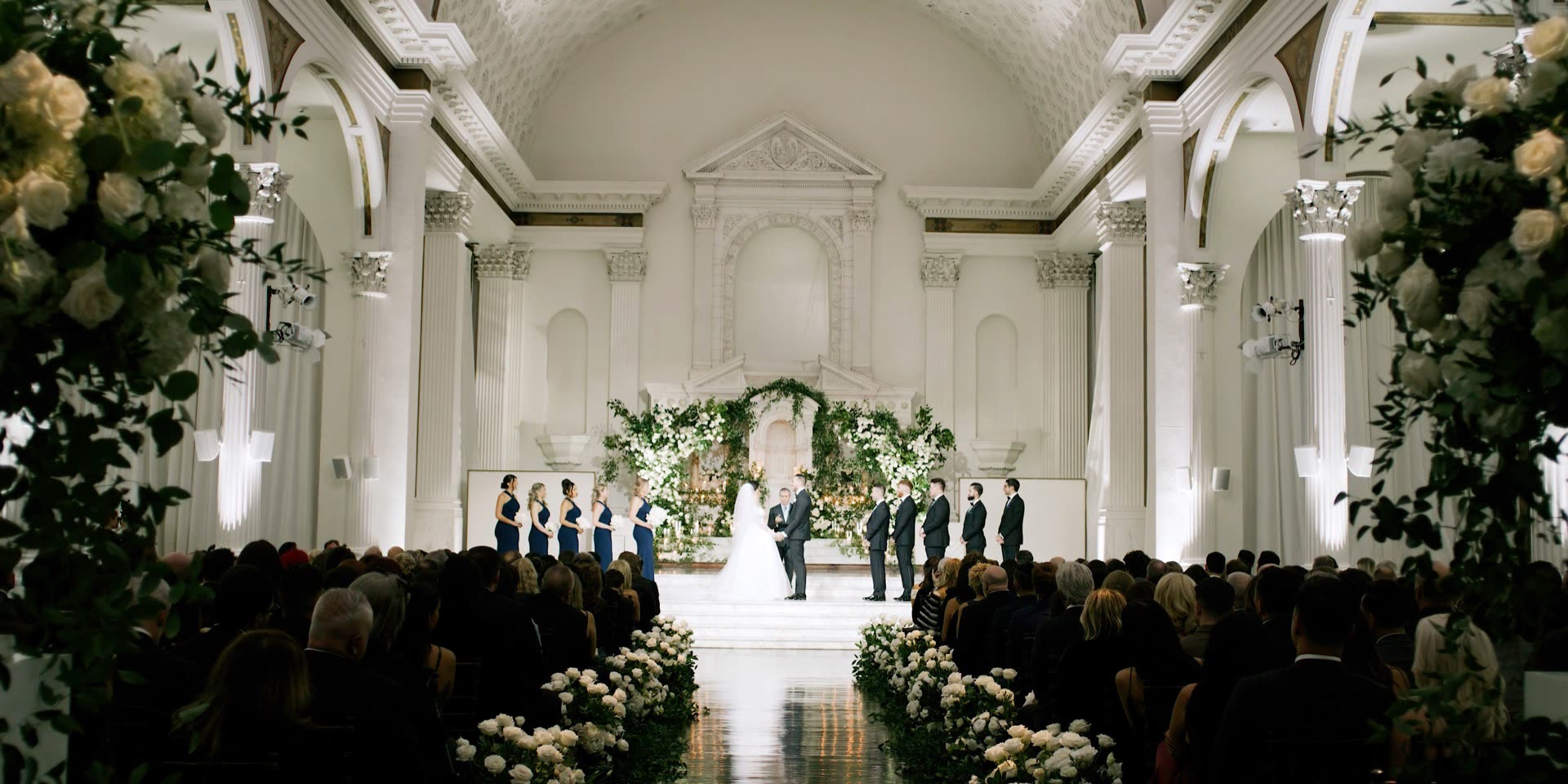 Wedding ceremony in the Vibiana nave in downtown Los Angeles, guests seated beneath the Corinthian columns