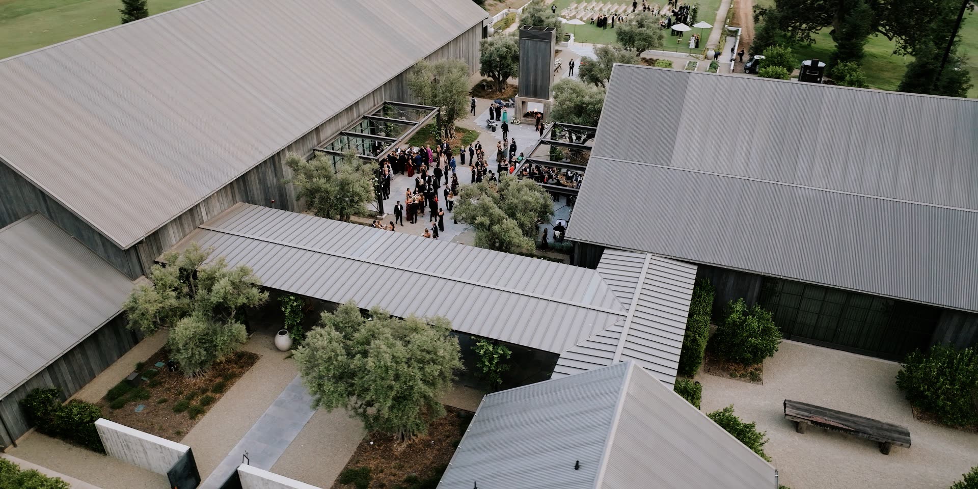 Aerial view of guests gathered in the Ojai Valley Inn Farmhouse courtyard among olive trees