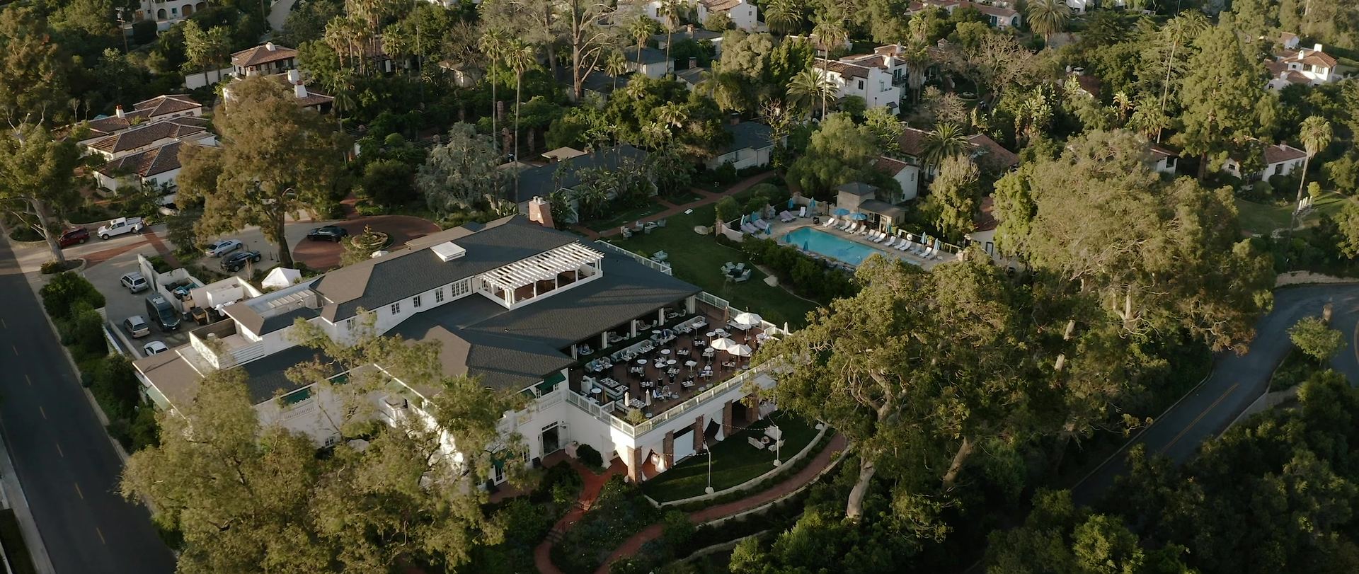 Belmond El Encanto from the air, the main building's terrace set for dinner, the pool and cottages among the trees.