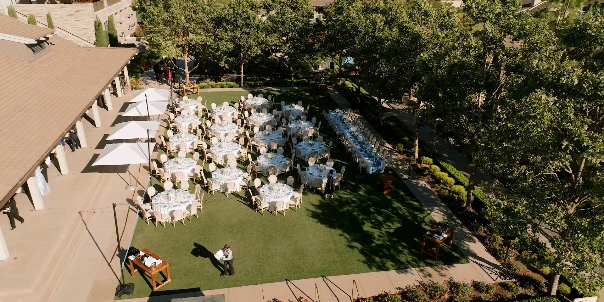 Aerial view of the Rosewood Sand Hill reception lawn set with round tables and a long head table