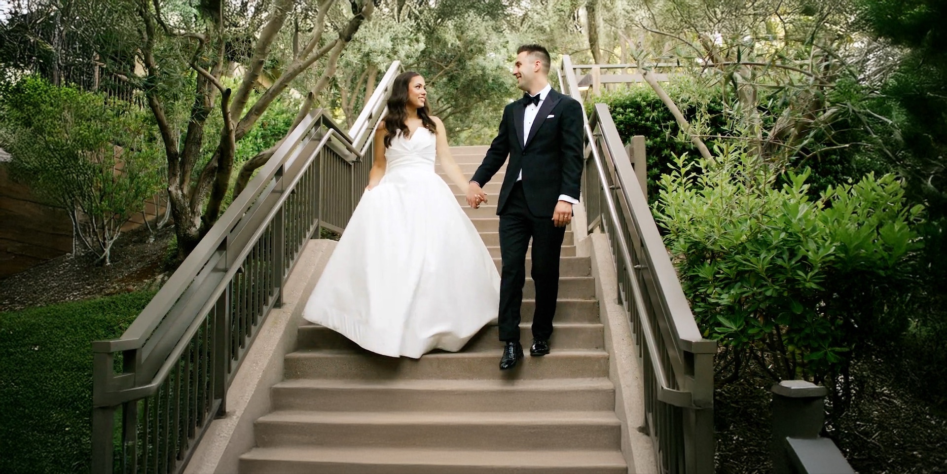 Bride and groom descending the garden staircase at Rosewood Sand Hill in Menlo Park, framed by olive trees