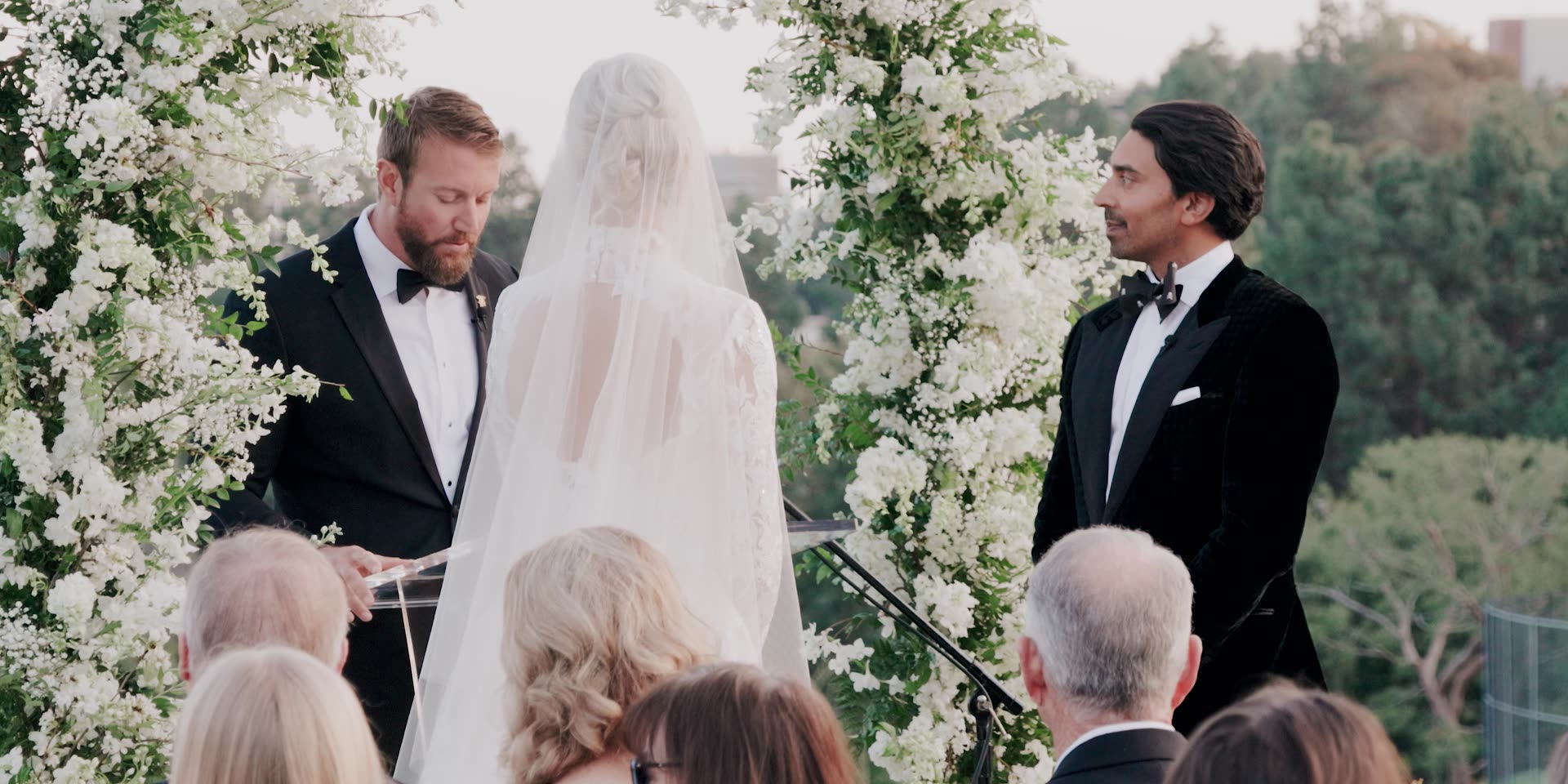 Sumil and Krista's ceremony beneath the white floral arch at Bel-Air Country Club