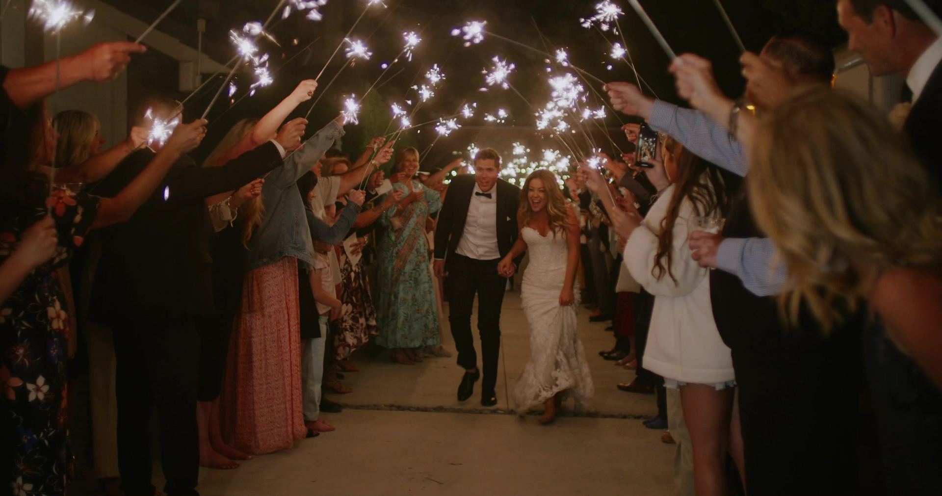 The send-off at the end of the night, guests holding sparklers overhead.