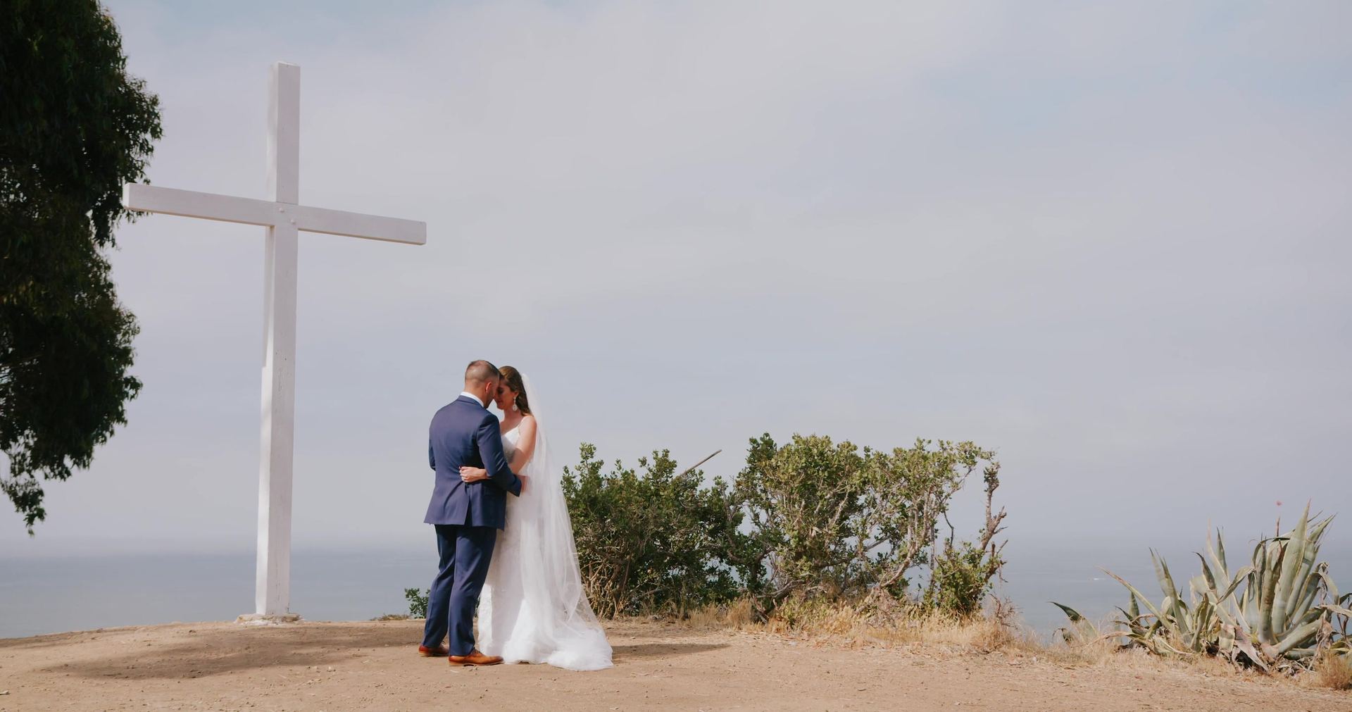 Timothy and Amber together at the hilltop cross above the water.