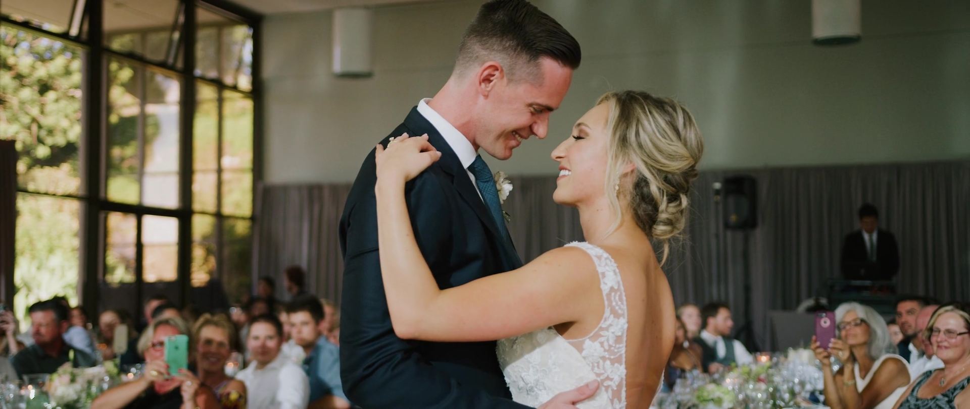 Their first dance, guests gathered at the tables around them.